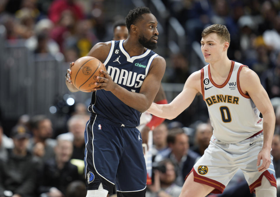 Dallas Mavericks guard Theo Pinson, left, looks to pass the ball as Denver Nuggets guard Christian Braun defends in the second half of an NBA basketball game Wednesday, Feb. 15, 2023, in Denver. (AP Photo/David Zalubowski)