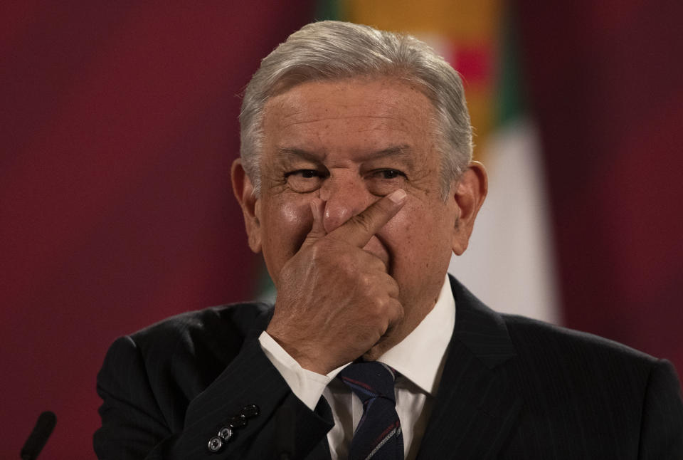 Mexican President Andres Manuel Lopez Obrador rubs his nose as he gives his daily, morning news conference at the presidential palace, Palacio Nacional, in Mexico City, Friday, Oct. 16, 2020. López Obrador said Friday that his ambassador to the United States told him two weeks ago that there was an investigation underway there involving Mexico's former defense secretary, retired Gen. Salvador Cienfuegos, who was arrested Thursday in Los Angeles. (AP Photo/Marco Ugarte)