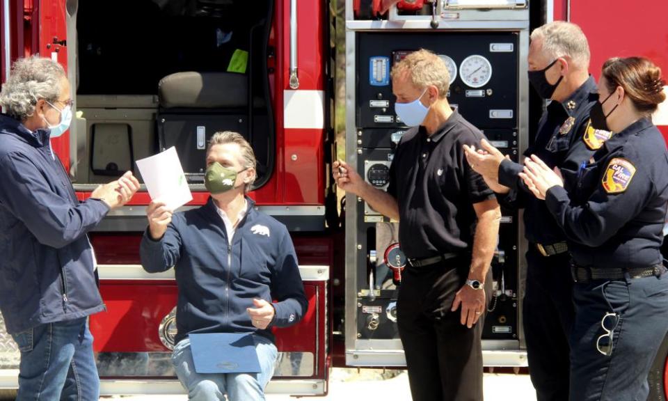 Gavin Newsom, seated, hands recently signed legislation to the state assemblyman Richard Bloom, left, shortly after signing a law authorizing more than half a billion dollars in new spending to prepare for wildfire season.