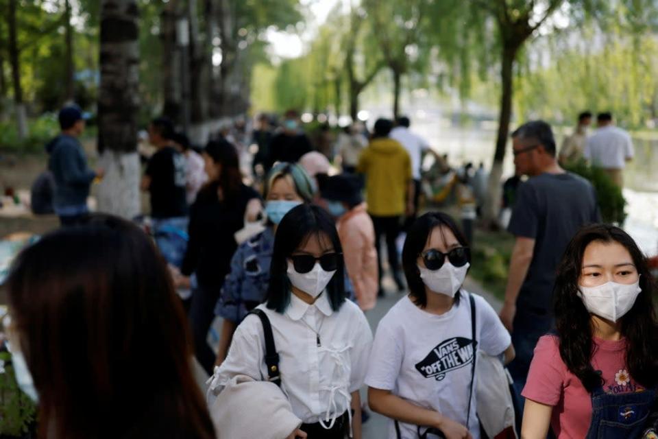 People enjoy the sun in a public park in Beijing amid a Covid-19 outbreak (Reuters)