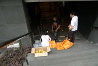 Goodie bags containing a paper fan, a box of cereal and a bottle of water are given out to customers in the queue. (Yahoo! photo)