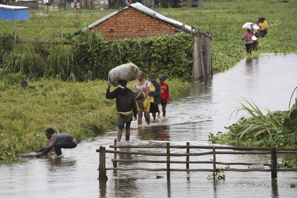 FILE - Residents wade through flood water around their homes after heavy rain in Antananarivo, on Jan. 19, 2022. Rich countries say they will spend about $25 billion by 2025 to boost Africa’s efforts to adapt to climate change as the continent continues to struggle with drought, cyclones and extreme heat, according to officials at a summit in Rotterdam in the Netherlands. (AP Photo/Alexander Joe, File)