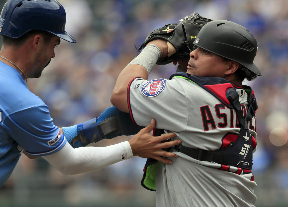 Kansas City Royals' Whit Merrifield, left, is tagged out by Minnesota Twins catcher Willians Astudillo, right, during the first inning of a baseball game at Kauffman Stadium in Kansas City, Mo., Saturday, June 22, 2019. (AP Photo/Orlin Wagner)