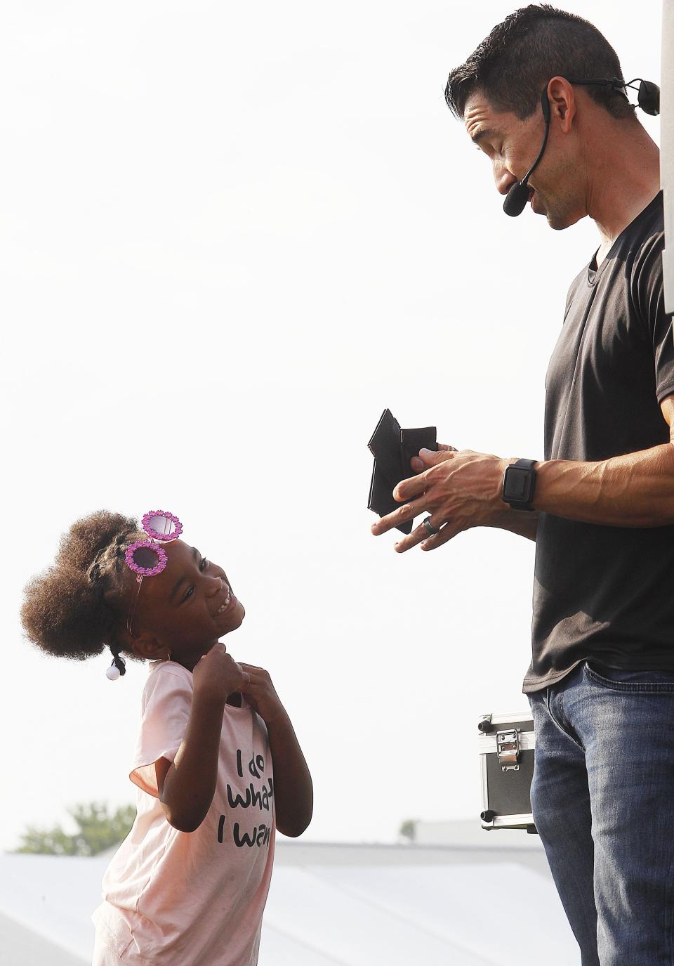 Kylee Ronny, 6, helps Dana Hill from the "Almost Amazing Rex and Dana" with a magic trick July 16.