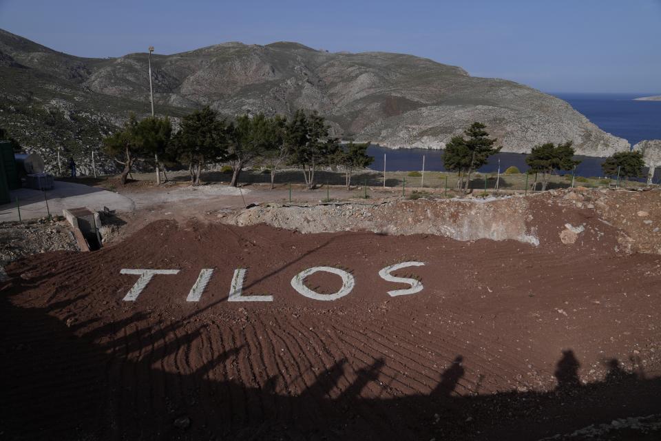 The shadows of visitors are seen on the old landfill on the Aegean Sea island of Tilos, southeastern Greece, Monday, May 9, 2022. When deciding where to test green tech, Greek policymakers picked the remotest point on the map, tiny Tilos. Providing electricity and basic services, and even access by ferry is all a challenge for this island of just 500 year-round inhabitants. It's latest mission: Dealing with plastic. (AP Photo/Thanassis Stavrakis)