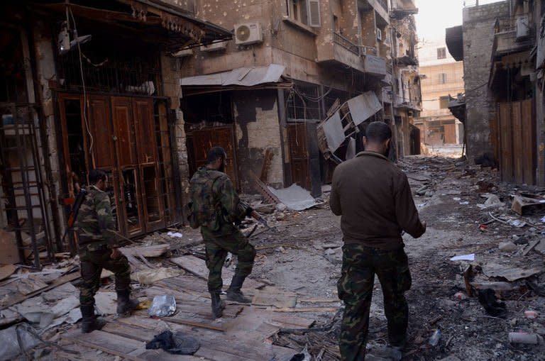 Syrian government forces walk through the old souk in the northern Syrian city of Aleppo on January 3, 2012, after they allegedly recaptured the area from opposition forces. At least nine people were killed when a car bomb exploded in the Syrian capital Damascus, the Syrian Observatory for Human Rights said early Friday