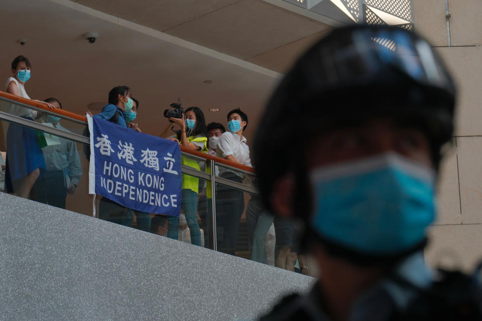 A police officer stands guard as protesters gather at a shopping mall in Central during a pro-democracy protest against Beijing's national security law in Hong Kong, Tuesday, June 30, 2020. Hong Kong media are reporting that China has approved a contentious law that would allow authorities to crack down on subversive and secessionist activity in Hong Kong, sparking fears that it would be used to curb opposition voices in the semi-autonomous territory. (AP Photo/Vincent Yu)