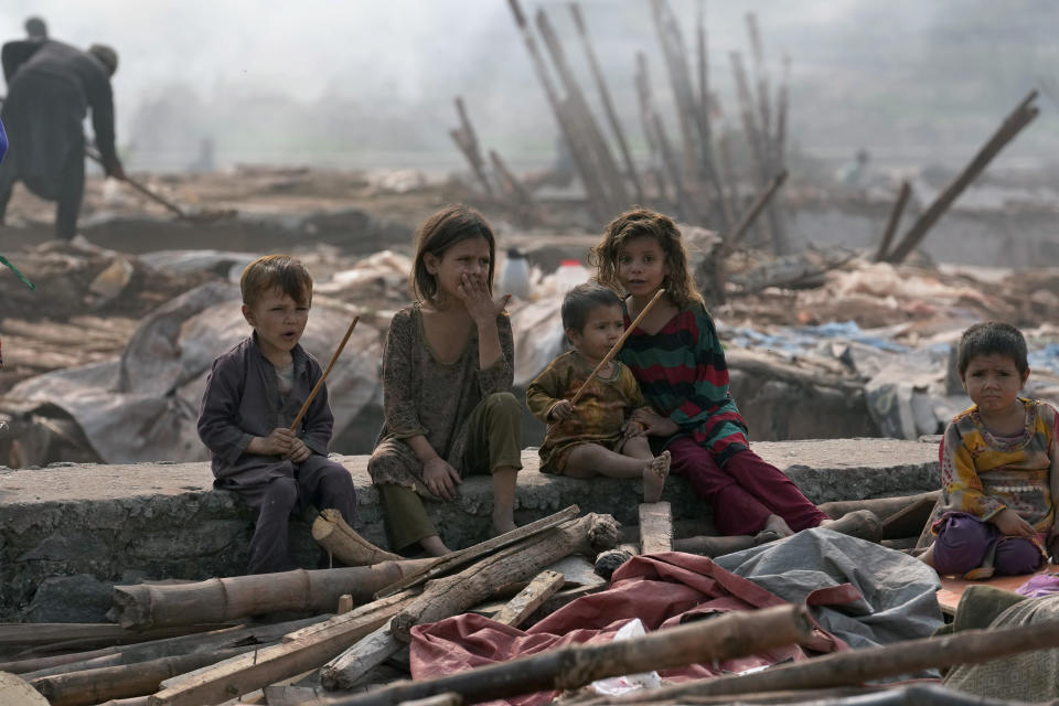 Afghan children sit beside their family's belongings retrieved from their damaged mud homes demolished by authorities during a crackdown against an illegal settlement and immigrants, on the outskirts of Islamabad, Pakistan, Wednesday, Nov. 1, 2023. (AP Photo/Anjum Naveed)