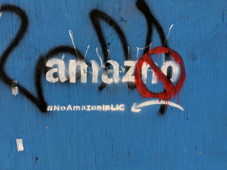 FILE PHOTO: Graffiti opposing the construction of the new Amazon campus covers a fence at a vacant lot in the Long Island City neighborhood of New York City, U.S. December 5, 2018. REUTERS/Nandita Bose/File Photo