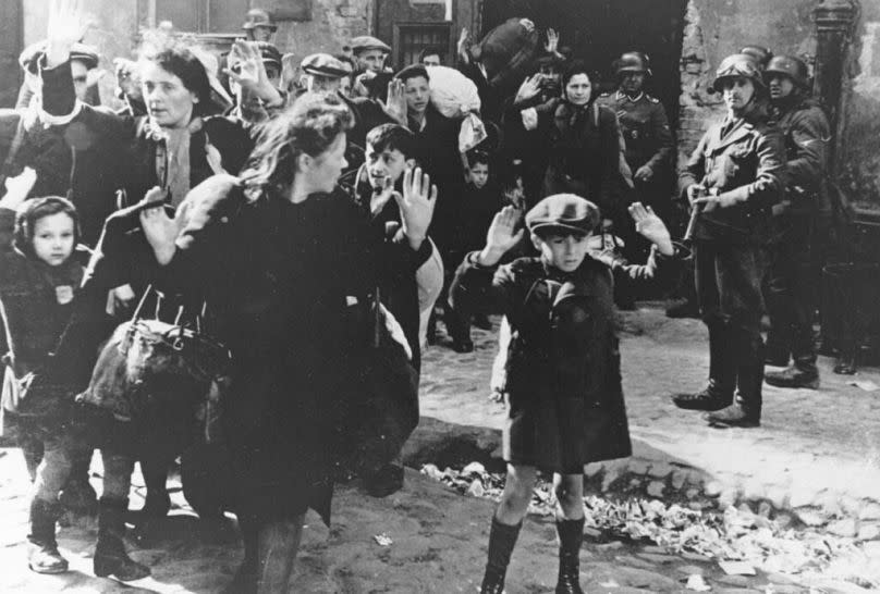 ** FILE ** A group of Jews, including a small boy, is escorted from the Warsaw Ghetto by German soldiers on April 19, 1943.