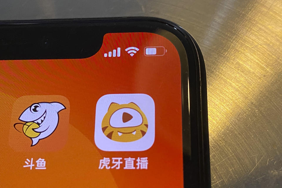 The apps Douyu at left and Huya at right are seen on a screen in Beijing on Saturday, July 10, 2021. China's market regulator on Saturday blocked the merger of Tencent-backed game streaming platforms Douyu and Huya following an anti-monopoly investigation, as authorities ramp up scrutiny of some of the country's biggest technology companies. (AP Photo/Ng Han Guan)