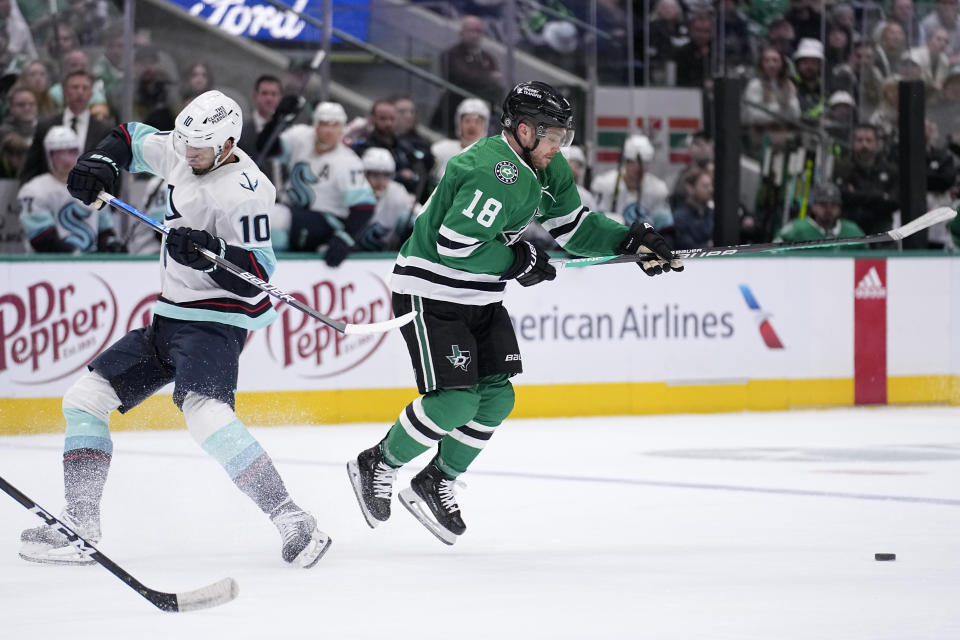 Dallas Stars center Max Domi (18) side steps a hit attepted by Seattle Kraken center Matty Beniers (10) as Domi pursues the puck in the first period of an NHL hockey game, Tuesday, March 21, 2023, in Dallas. (AP Photo/Tony Gutierrez)