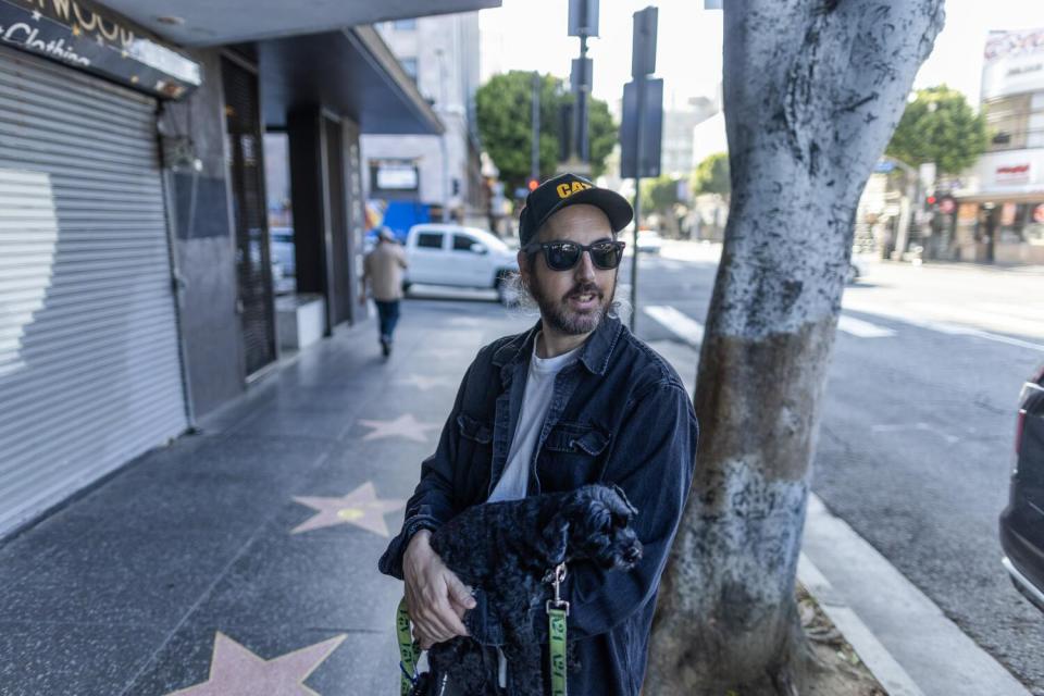 A man and his dog hang out on Hollywood Blvd.