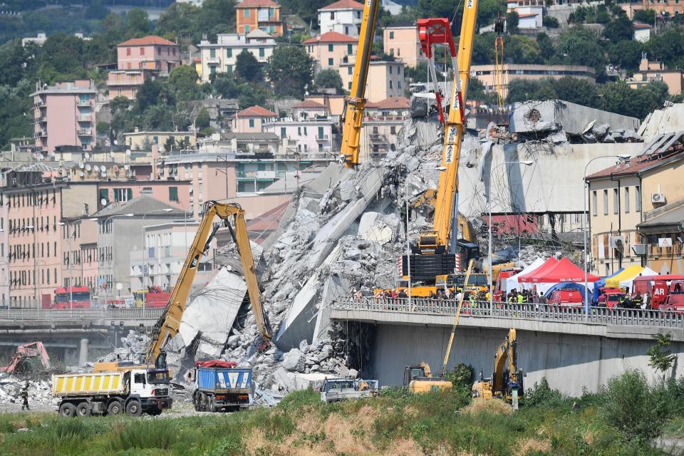 Caterpillars remove debris from the collapsed Morandi highway bridge, in Genoa, Italy, Friday, Aug. 17, 2018. Officials say 38 people are confirmed killed and 15 injured. Prosecutors say 10 to 20 people might be unaccounted-for and the death toll is expected to rise. (Luca Zennaro/ANSA via AP)