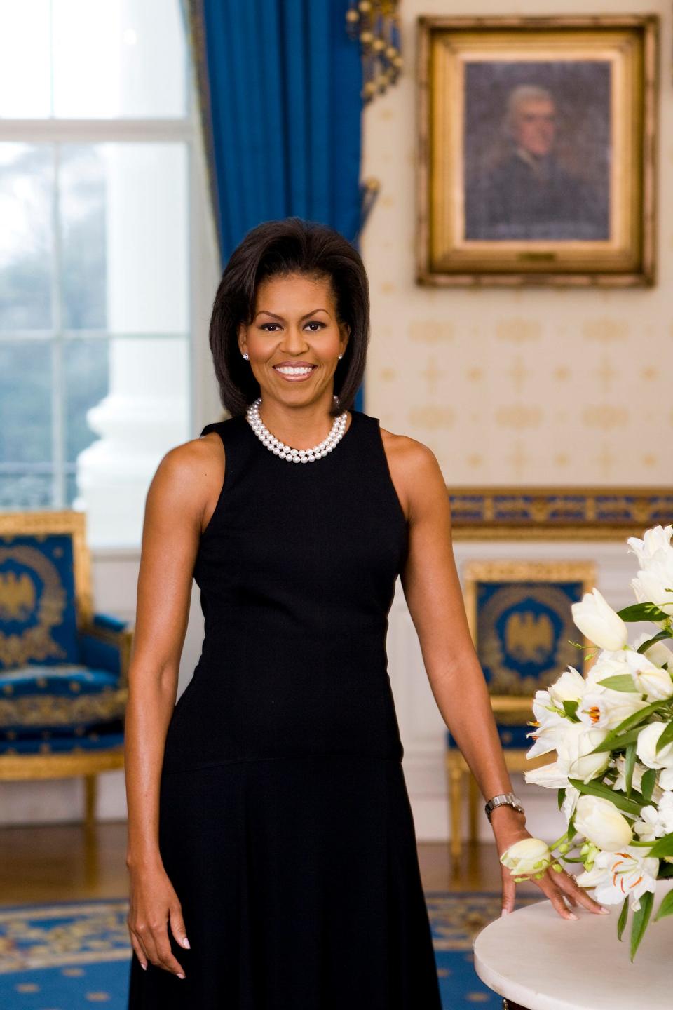 Michelle Obama's official White House portrait. She wears a black sleeveless sheath dress.