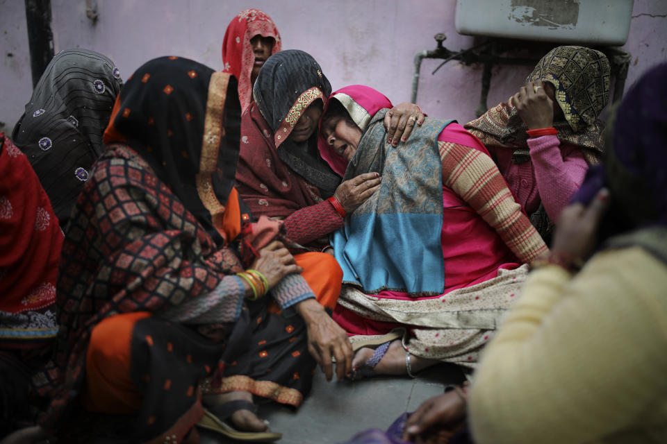 Family members of Rahul Solanki, who was killed during clashes between mobs of Hindus and Muslims protesting a contentious new citizenship law, cry outside a mortuary in New Delhi, India, Wednesday, Feb. 26, 2020. The law fast-tracks naturalization for foreign-born religious minorities of all major faiths in South Asia except Islam. (AP Photo/Altaf Qadri)