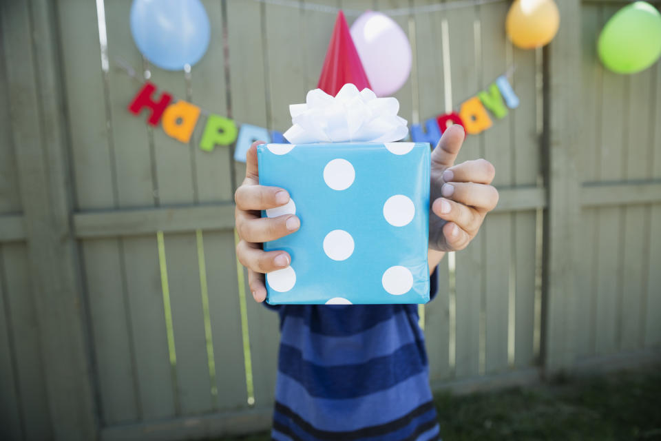 Boy holding polka-dot wrapped birthday gift