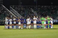 North Carolina Courage and Racing Louisville FC players pause and gather at midfield during the first half of an NWSL soccer match in Cary, N.C., Wednesday, Oct. 6, 2021. (AP Photo/Gerry Broome)