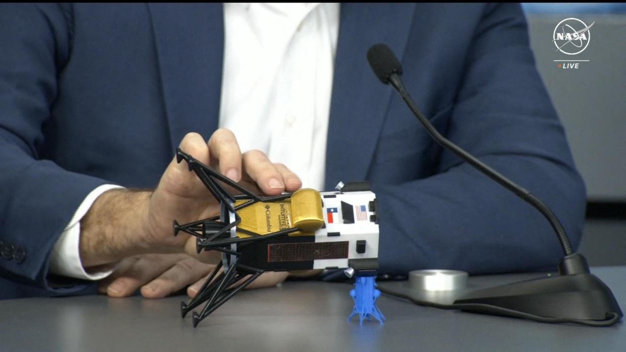 Intuitive Machines CEO Steve Altemus holds a model of the Odysseus lunar lander to show its position on the side during a press conference at Johnson Space Center in Houston, Texas on February 23, 2024, in this screen grab from NASA. The lander probably face-planted into the dirt after catching on a rock during its dramatic landing, he said.