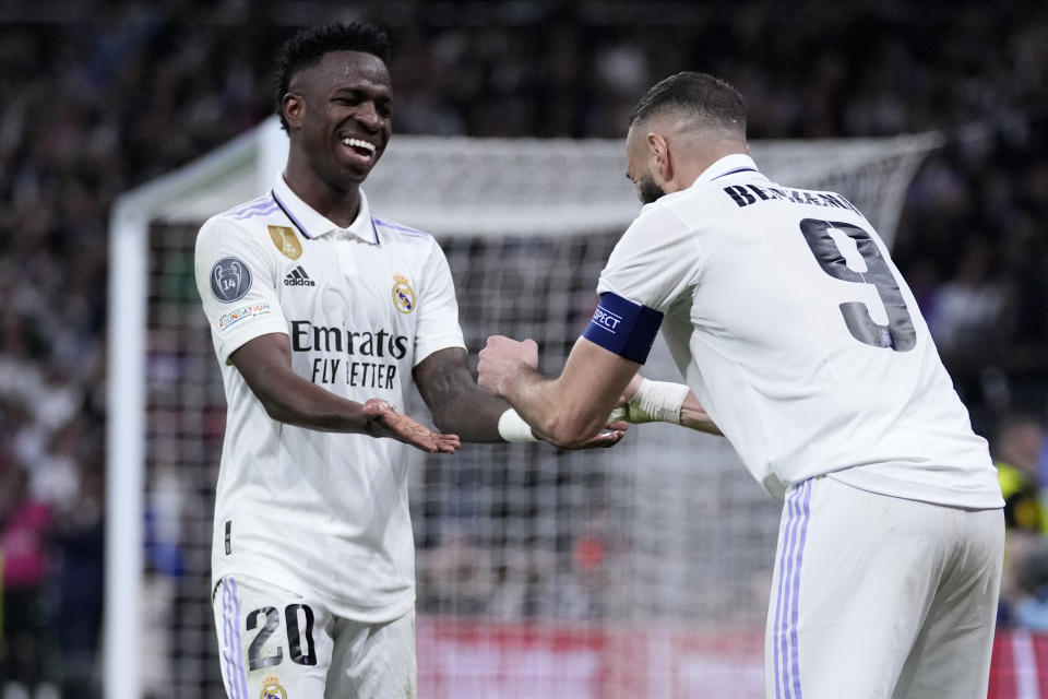 Karim Benzema (derecha) del Real Madrid celebra con Vinicius Junior tras marcar el primer gol ante Liverpool en el duelo de octavos de final de la Liga de Campeones, el miércoles 15 de marzo de 2023, en Madrid. (AP Foto/Bernat Armangue)