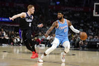 Los Angeles Clippers guard Paul George (13) is defended by Sacramento Kings guard Donte DiVincenzo (0) during the first half of an NBA basketball game Saturday, April 9, 2022, in Los Angeles. (AP Photo/Marcio Jose Sanchez)