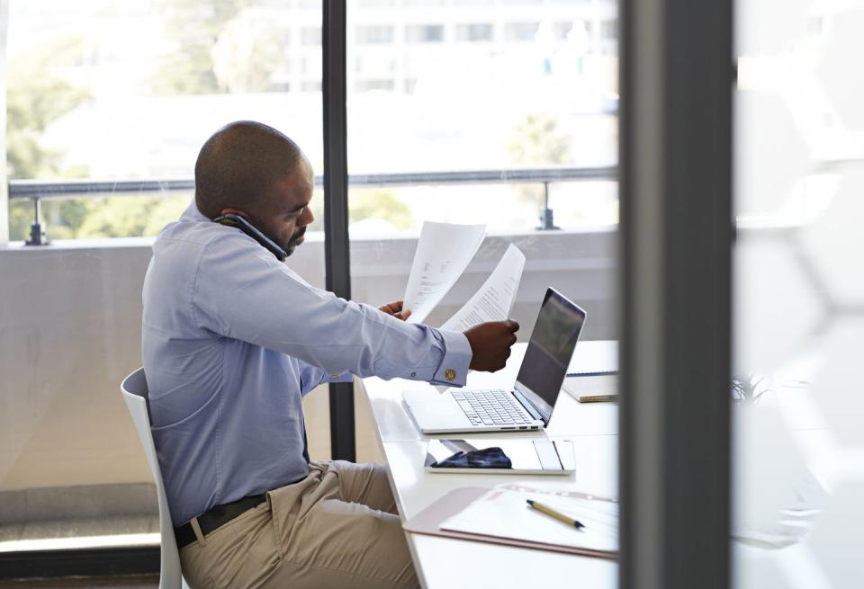 businessman on phone and looking threw papers