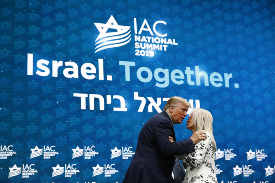 President Donald Trump embraces Miriam Adelson, the wife of Las Vegas Sands Corporation Chief Executive and Republican mega donor Sheldon Adelson, as she introduces him at the Israeli American Council National Summit in Hollywood, Fla., Saturday, Dec. 7, 2019. (AP Photo/Patrick Semansky)