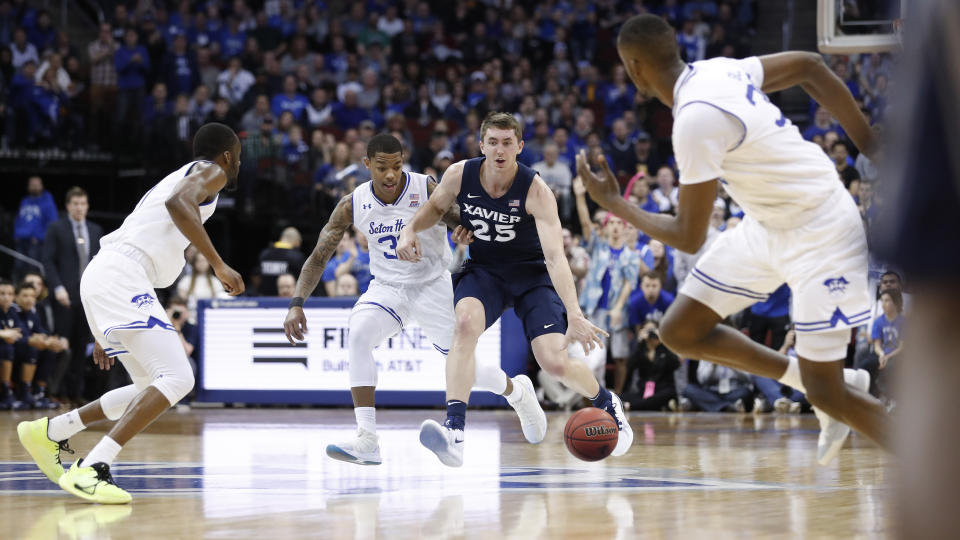 Xavier's Jason Carter (25) dribbles down the court against Seton Hall's Shavar Reynolds, center left, during the first half of an NCAA college basketball game, Saturday, feb. 1, 2020, in Newark, N.J. (AP Photo/Michael Owens)