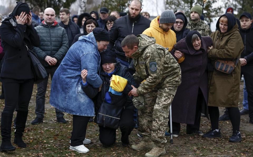 Family members grieve during the funeral at Bucha City Cemetery of 44 year old Maksym Kropyva, killed in action - Jeff J Mitchell/Getty Images