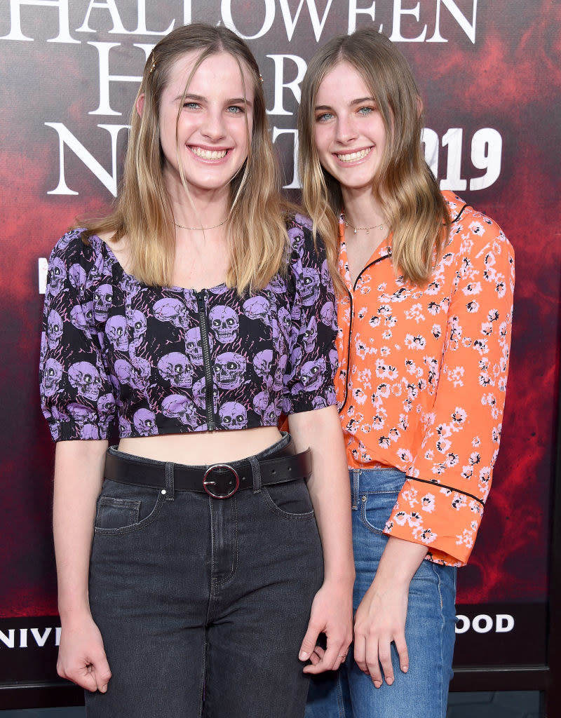 the twins as adults smiling and standing together