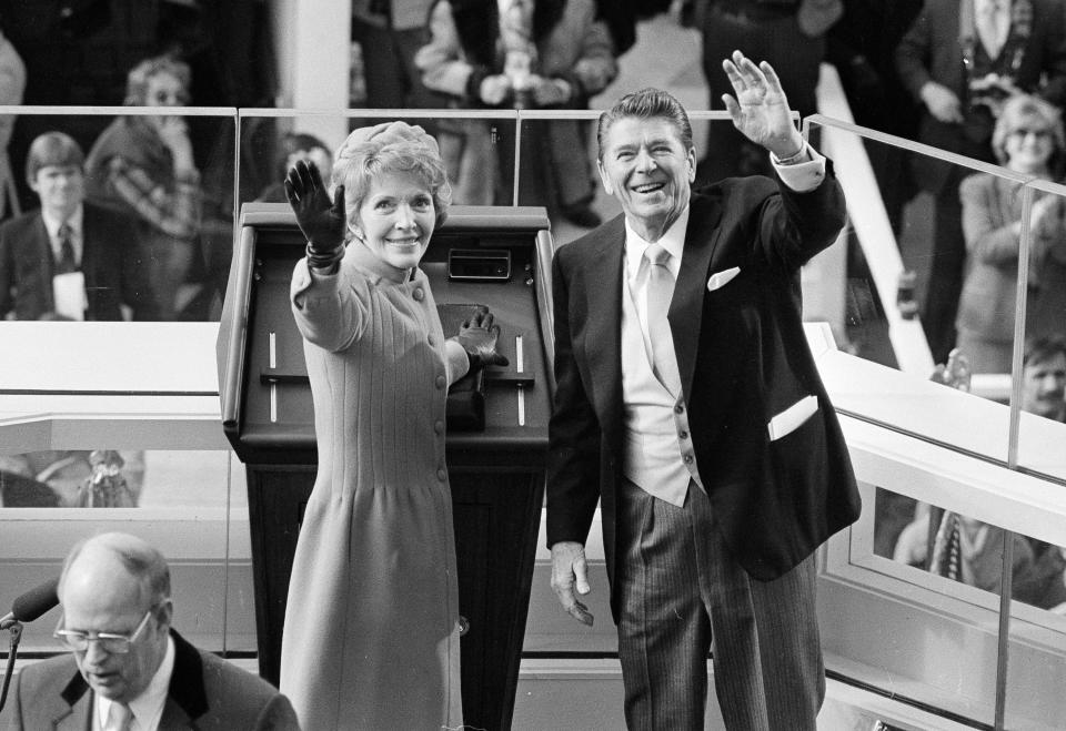 FILE - In this Jan. 20, 1981, file photo, President Ronald Reagan and first lady Nancy Reagan wave to onlookers at the Capitol building as they stand at the podium in Washington following the swearing in ceremony. (AP Photo/File)