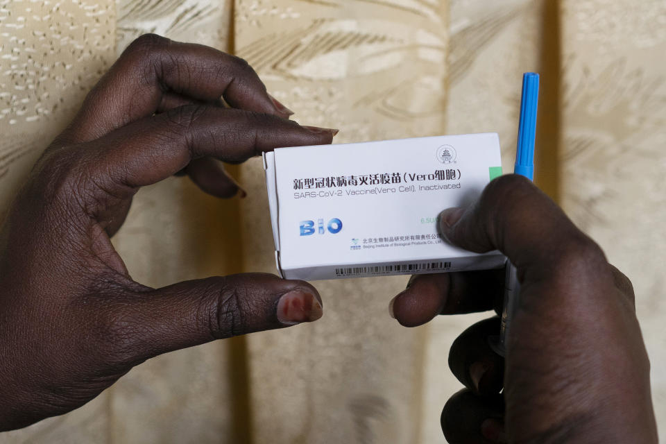 FILE - In this Tuesday, Feb. 23, 2021, file photo, a health worker holds a box containing a dose of China's Sinopharm vaccine during the start of the vaccination campaign against the COVID-19 at the Health Ministry in Dakar, Senegal. China’s vaccine diplomacy campaign has pledged roughly half a billion doses of its vaccines to dozens of countries. (AP Photo/Leo Correa, File)