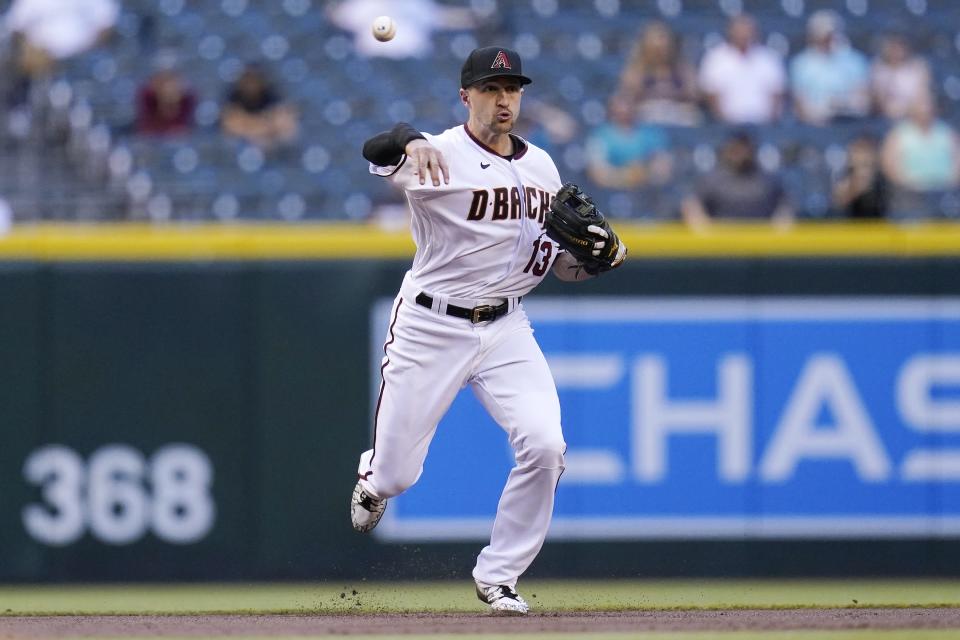 Arizona Diamondbacks shortstop Nick Ahmed throws to first base to get Miami Marlins' Adam Duvall out during the first inning of a baseball game Thursday, May 13, 2021, in Phoenix. (AP Photo/Ross D. Franklin)