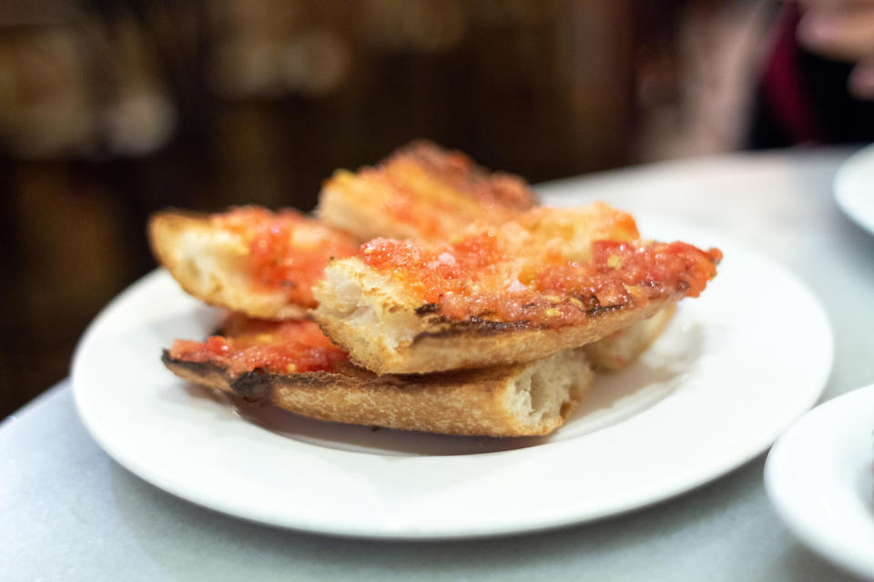 Slices of bread topped with tomato on a white plate