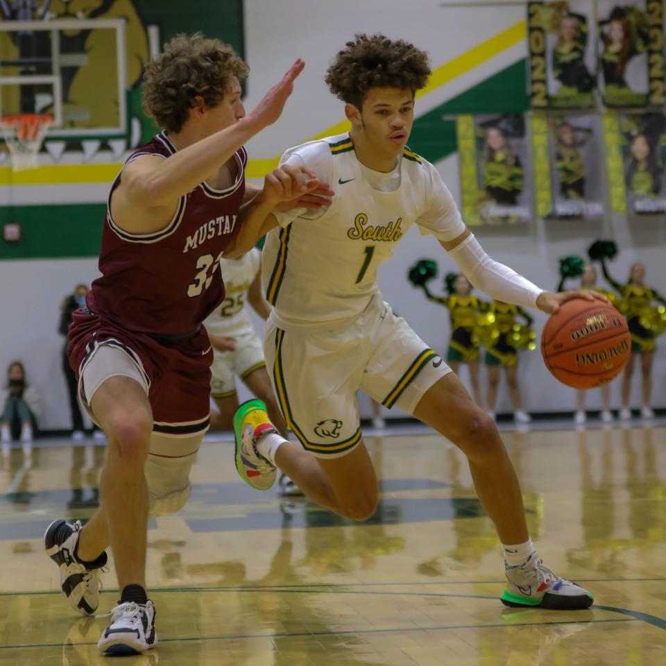 Salina South's Te'Jon McDaniel (1) dribbles past Salina Central's Nolan Puckett (33) during Friday's game at the South gym.