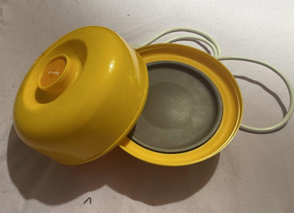 Vintage yellow egg cooker with lid open revealing cooking tray and electric cord