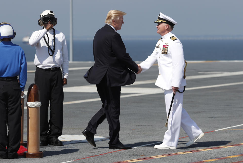 FILE - In this July 22, 2017, file photo, President Donald Trump shakes hands with Ship Captain Rick McCormack as he arrives for the the commissioning ceremony of the aircraft carrier USS Gerald R. Ford (CVN 78) at Naval Station Norfolk, Va. Trump’s vision of America’s tomorrows looks much like its yesterdays. He loves “beautiful” coal. “Beautiful” warships. And “those four beautiful words: MADE IN THE USA!” He speaks of the country’s might as measured by its steel mills, farms and cars rolling off Detroit assembly lines. (AP Photo/Carolyn Kaster, File)