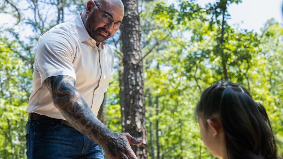 Dave Bautista stretching his hand out to a little girl