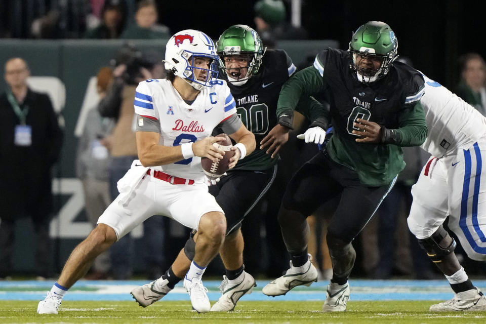 Southern Methodist quarterback Tanner Mordecai (8) scrambles under pressure from Tulane linebacker Devean Deal (90) and defensive lineman Patrick Jenkins (0) during the first half of an NCAA college football game in New Orleans, Thursday, Nov. 17, 2022. (AP Photo/Gerald Herbert)