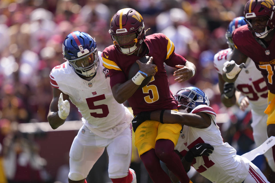 Washington Commanders quarterback Jayden Daniels (5) is tackled by New York Giants safety Jason Pinnock (27) during the first half of an NFL football game in Landover, Md., Sunday, Sept. 15, 2024. (AP Photo/Matt Slocum)