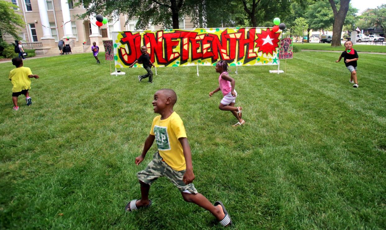 Kids have fun running around a Juneteenth celebration Friday.