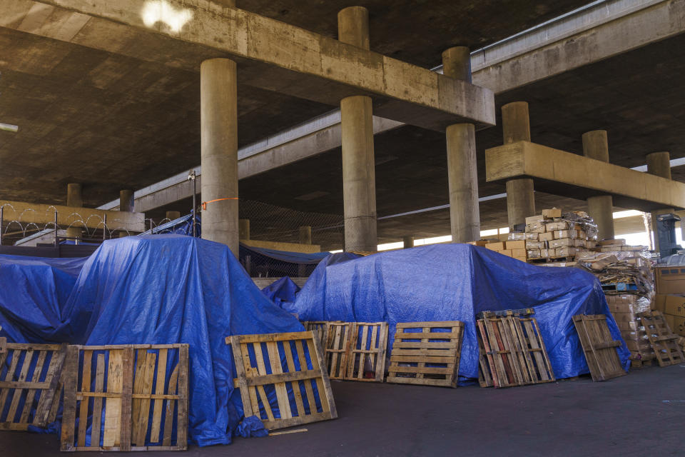 Traps cover merchandise stored under the Interstate 10 in Los Angeles, Thursday, Dec. 7, 2023. (AP Photo/Damian Dovarganes)