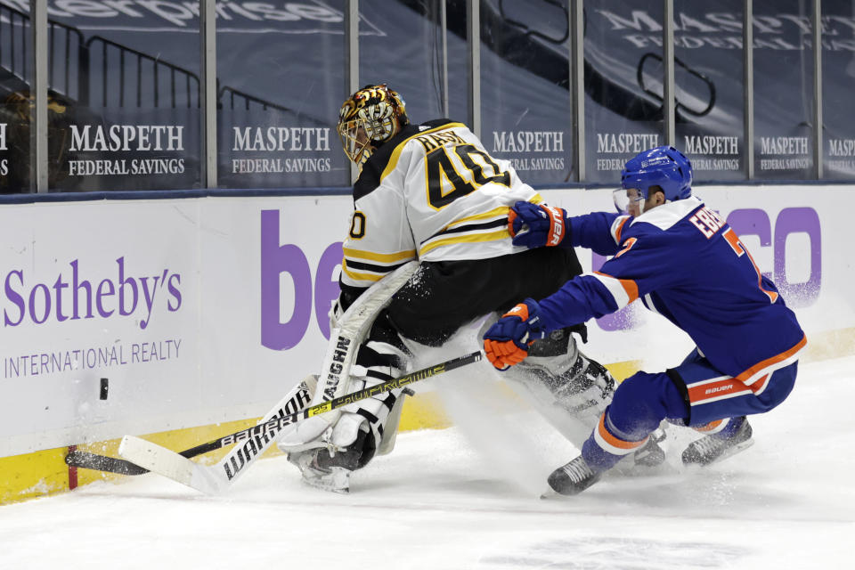 Boston Bruins goaltender Tuukka Rask (40) clears the puck in front of New York Islanders right wing Jordan Eberle during the second period of an NHL hockey game Saturday, Feb. 13, 2021, in Uniondale, N.Y. (AP Photo/Adam Hunger)
