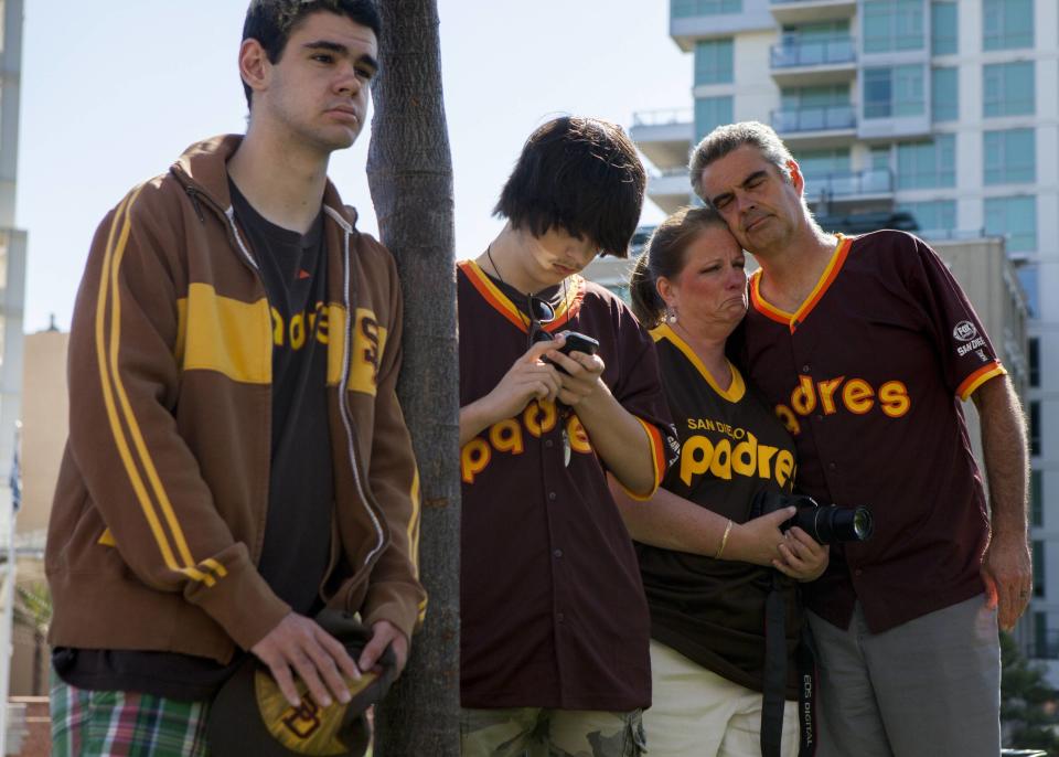 Alex Mcbrayer, Trevor Herman, Rebecca Herman, and her friend Wayne Mcbrayer mourn at a makeshift memorial to former San Diego Padres outfielder Tony Gwynn at Petco Park in San Diego