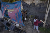 Bedouin kids walk a donkey at the West Bank hamlet of Khan al-Ahmar, Sunday, Jan. 22, 2023. The long-running dispute over the West Bank Bedouin community of Khan al-Ahmar, which lost its last legal protection against demolition four years ago, resurfaced this week as a focus of the frozen Israeli-Palestinian conflict. Israel's new far-right ministers vow to evacuate the village as part of a wider project to expand Israeli presence in the 60% of the West Bank over which the military has full control. Palestinians seek that land for a future state. (AP Photo/Oded Balilty)