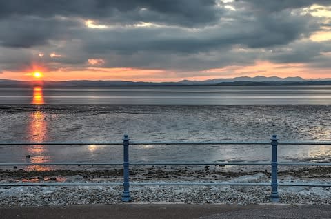 The sun sets over Morecambe Bay with the Lake District in the distance - Credit: ISTOCK