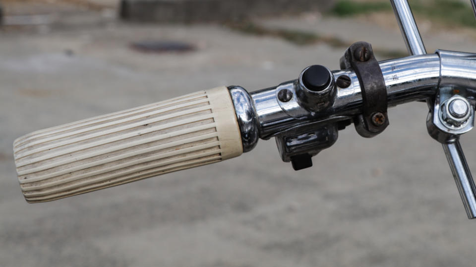 Rotating the left hand grip allows the rider to advance or retard the engine timing. The button operates the horn and the switch controls the hi/low beam.