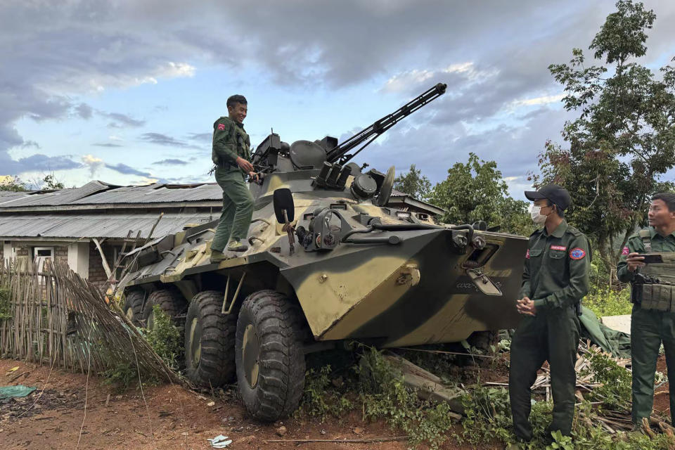 CORRECTS THE FIRST SENTENCE FROM POSING IN FRONT OF WEAPONS TO CHECKING AN ARMY ARMORED VEHICLE - In this photo provided by the Kokang online media, members of an ethnic armed forces group, one of the three militias known as the Three Brotherhood Alliance, check an army armored vehicle the group allegedly seized from Myanmar's army outpost on a hill in Hsenwi township in Shan state, Myanmar, on Nov. 24, 2023. A major offensive against Myanmar's military-run government by an alliance of three militias of ethnic minorities has been moving at lightning speed, inspiring resistance forces around the country to attack. (The Kokang online media via AP)