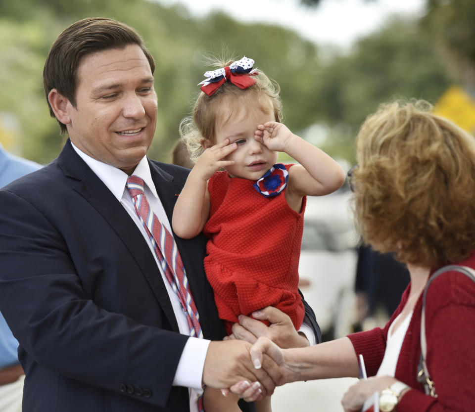 Gubernatorial candidate Ron DeSantis greets a voter as his daughter Madison rubs her eyes after DeSantis and his wife voted on Election Day, Tuesday, Nov. 6, 2018 at Our Lady of the Sea Church in Ponte Vedra Beach, Fla. (Will Dickey/The Florida Times-Union via AP)