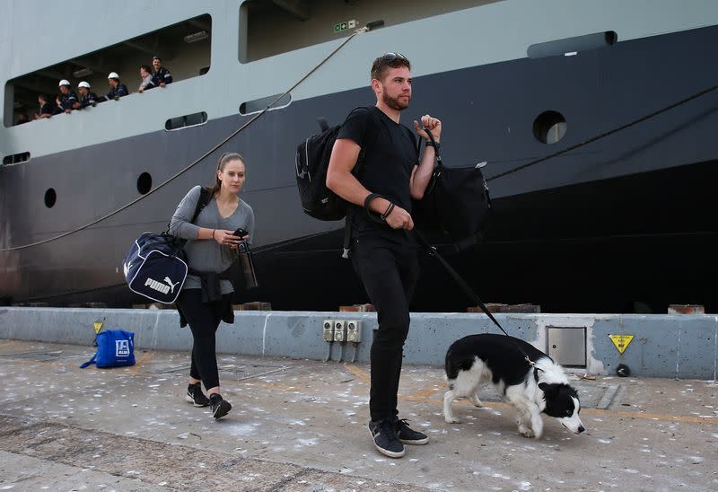 Evacuees and their Border Collie dog arrive from Mallacoota on the navy ship MV Sycamore at the port of Hastings, Victoria, Australia